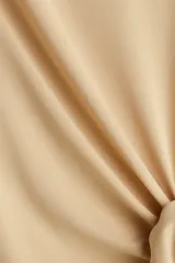 Vestido corto de punto color beige, con cuello redondo y mangas cortas. Presenta un nudo fruncido en el lateral que crea un efecto drapeado y abertura en el ruedo.