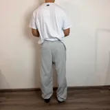 Pantalon sastrero de corte baggy, color gris claro, con pinzas en la cintura y cierre frontal.