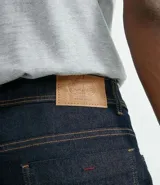 Pantalón jean de corte recto, color azul oscuro, con costuras en contraste y bolsillos traseros clásicos.