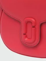 Bandolera Marc Jacobs modelo The Saddle Bag, color negro, de cuero con logo grabado en el frente.