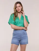 Short de denim blanco tiro alto, estilo pull-on con cintura elástica ancha, bolsillos delanteros y traseros, y dobladillo en las piernas.