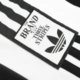 Pantalón Adidas modelo Adibreak, de color negro con paneles laterales blancos y las icónicas tres tiras de la marca. Cuenta con botones a presión en los laterales y corte holgado.