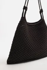 Bolso tipo shopper de tejido macramé marrón oscuro, con forma trapezoidal y asas de hombro trenzadas.