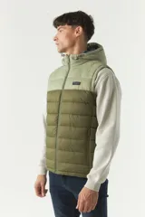 Chaleco negro acolchado con capucha ajustable, cierre frontal y bolsillos laterales con cierre. Logo de la marca en el pecho. Colección Otoño Invierno 2025. El modelo usa talle M. Composición 100% nylon.