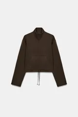 Sudadera de algodón con cuello subido y cierre frontal con cremallera. Presenta mangas largas, bolsillo tipo canguro frontal y bajo ajustable con cordones.