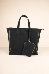 Bolso tipo tote bag negro con tachas plateadas en los bordes y monedero extraíble.