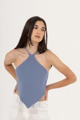 Top de tejido de punto color crema, con cuello halter y espalda descubierta.