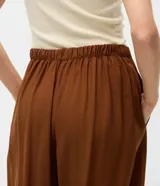 Pantalón de sastrería modelo aladim color marrón, con cintura recta, piernas amplias y ruedo ajustado. Confeccionado en tejido fluido de viscosa y poliéster.
