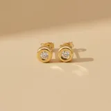 Par de caravanas tipo stud en oro amarillo 18k con engaste de brillante central.