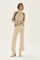 Jean de tiro alto y pierna ancha, color beige claro, con terminación deshilachada en el ruedo.