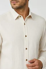 Camisa de viscosa color negro, de manga larga, con cuello camisero y cierre frontal de botones.