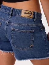 Short de denim azul de tiro medio, con corte wide leg y bordes deshilachados sin rematar.
