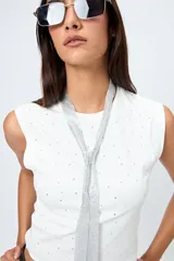 Top blanco sin mangas con apliques de strass, de silueta ajustada y tejido con acabado suave.
