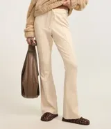 Pantalón de sastrería modelo flare en color beige, confeccionado en tejido de viscosa. Presenta un diseño de tiro alto con lazo ajustable en la cintura y detalle de friso vertical a lo largo de las piernas que estiliza la figura.