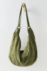 Bolso tote de ante suave, de cuerpo blando estilo hobo, con asa larga para el hombro y cierre superior con cremallera.