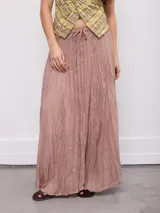 Falda larga mostaza, plisada, de corte amplio y fluido con pretina elástica y cordón ajustable en la cintura.
