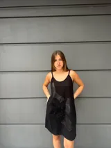 Vestido corto negro de algodón con breteles finos y apliques de cuero labrado. Corte suelto.