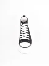 Zapatilla de caña alta con plataforma, confeccionada en lona negra con cordones y puntera de goma blanca.