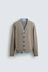 Cárdigan de punto con cuello en pico y manga larga. Presenta un diseño de ajuste relajado con cierre frontal de botones y acabados en rib con efecto doble en color azul a contraste sobre la base color topo.