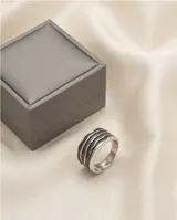 Anillo de plata 925 con acabado empavonado, diseño de banda ancha con relieve de líneas onduladas horizontales.