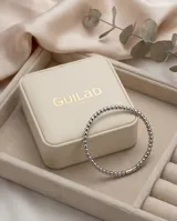 Pulsera esclava de acero inoxidable compuesta por pequeñas esferas metálicas unidas, con un cierre de seguridad rectangular integrado.