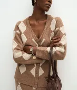 Cardigan de punto con estampado de cuadros argyle en tonos marrón y beige. Presenta escote en V, cierre frontal con botones, mangas largas con puños acanalados y corte recto.