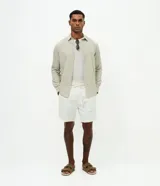 Bermuda de playa masculina de corte recto, confeccionada en algodón texturizado con diseño de rayas sutiles. Presenta cintura elástica con lazo de ajuste, bolsillos laterales y diseño sin estampa.