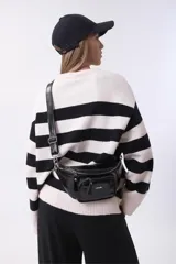 Sweater de tejido de punto con diseño de rayas horizontales anchas en color negro y crema, de corte holgado, cuello redondo y mangas largas.