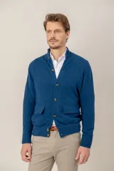 Sweater de lana lambswool color azul, con cierre frontal de botones, cuello alto y dos bolsillos frontales con solapa.