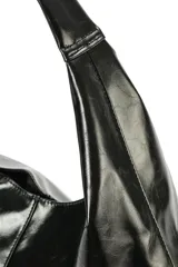 Cartera tipo slouchy color negro, confeccionada en 100% poliuretano simil cuero, con diseño amplio y asa de hombro integrada.