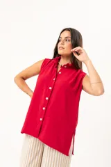 Camisa roja sin mangas con cuello mao adornado con un volado y cierre frontal con botones.