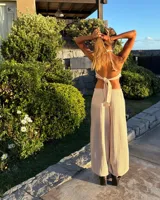 Top de punto color beige, con escote halter y espalda descubierta. Presenta un detalle de caracoles y cuentas en el bajo. Es de talle único y regulable.