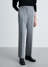Pantalón de vestir de corte recto y tiro medio, con diseño largo, trabillas en la cintura y bolsillos laterales. Cuenta con cierre oculto de botón, gancho y cremallera.