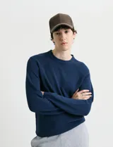 Sweater de punto inglés con escote redondo y mangas largas. Presenta cuello y puños terminados en punto canalé.