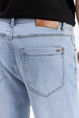 Jean de corte slim, color celeste con sutil efecto lavado, tiro medio y diseño clásico de cinco bolsillos.