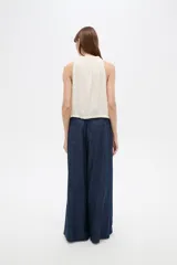Musculosa sin mangas color natural, confeccionada en viscosa, con cuello redondo base con frunces y elástico en la parte inferior.