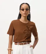 Remera de algodón marrón de manga corta y cuello redondo, con apliques tridimensionales de flores en relieve en el frente.