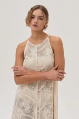 Vestido largo de red color crudo con estampado de flores, corte recto y cuello halter.