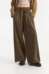 Pantalón ancho de tiro medio color verde militar, con cintura elástica a la vista con cordón de ajuste y pinzas delanteras.