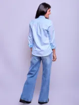 Camisa de vestir entallada a rayas verticales celestes y blancas, de manga larga y cuello clásico.