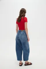 Pantalón de jean blanco de tiro medio, con diseño de silueta barrel, bolsillos clásicos y costuras con pinzas decorativas en la zona de las rodillas.