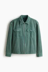 Sobrecamisa de pana de algodón color verde, con cuello clásico, cierre frontal de cremallera, mangas largas con puños abotonados y bolsillos superiores con solapa y botón.