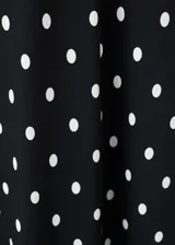 Vestido midi negro con estampado de lunares blancos, escote en pico con detalle de encaje, tirantes y diseño fluido de corte recto.