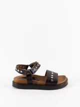 Sandalias marrones de cuero con plantilla anatómica forrada en cuero, acceso mediante pulsera regulable con velcro y detalle de tachas plateadas.