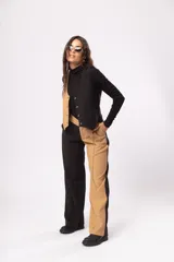 Pantalón fluido de tiro alto con bolsillos delanteros y traseros. Cierre frontal con cremallera y botón. Diseño color block negro y beige.