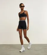 Bermuda deportiva seamless de color negro, con rayas contrastantes en la cintura. Ideal para la práctica de crossfit.