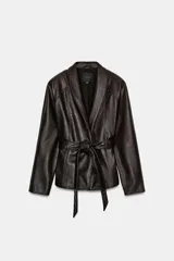 Chaqueta de Zara Woman Collection confeccionada en tejido efecto piel con textura granulada. Presenta cuello solapa, manga larga y cierre frontal con cinturón ajustable anudado a la cintura. Incluye forro interior.