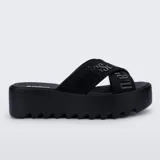 Sandalias Melissa modelo Cozy Slide de color negro, con plataforma gruesa dentada y tiras cruzadas de tela con el logotipo de la marca.