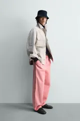 Pantalón relaxed fit color rosado, confeccionado en tejido de algodón con efecto lavado. Presenta pliegues frontales, bolsillos delanteros y bolsillos traseros de vivo. Cierre frontal con cremallera y botón.