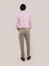 Pantalón de gabardina de corte slim fit y tiro medio, con diseño de cinco bolsillos y cierre de cremallera.